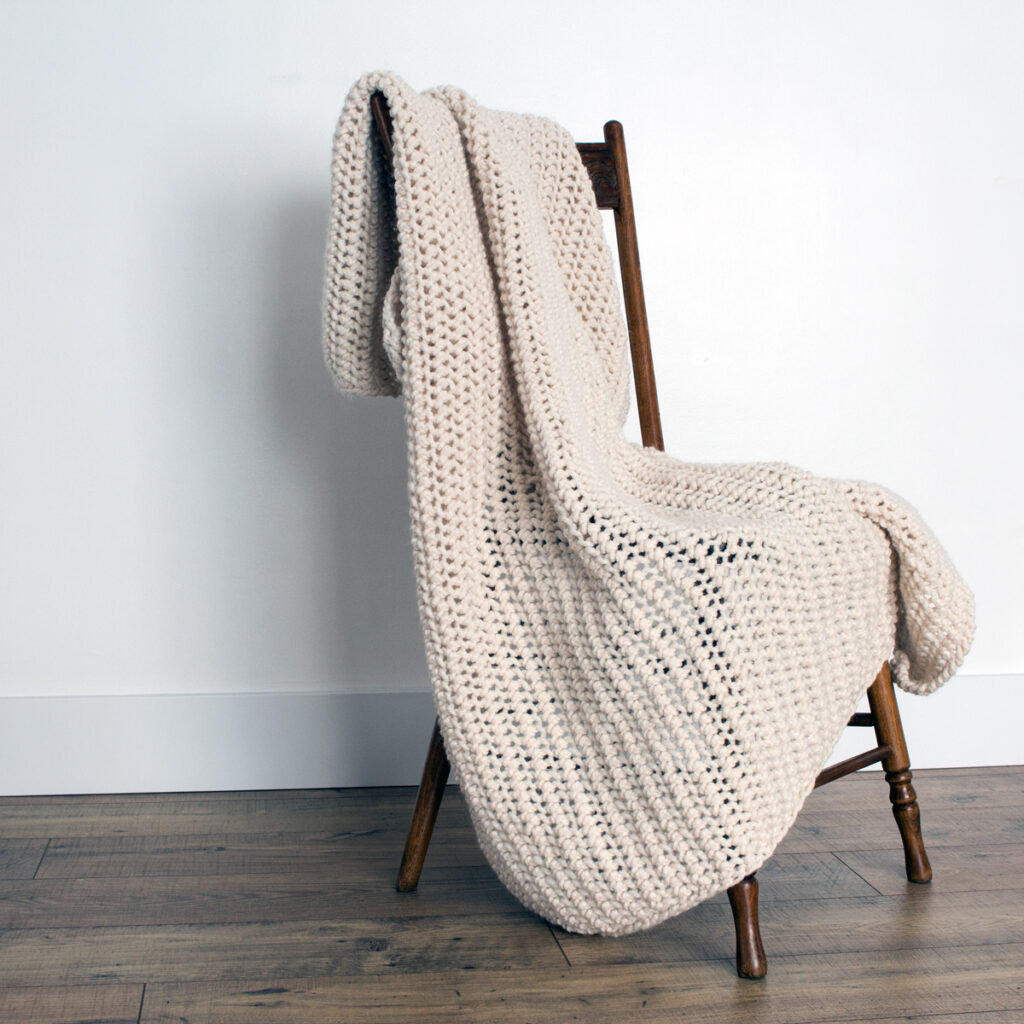 Crochet Knit Blanket draped over a wooden chair.