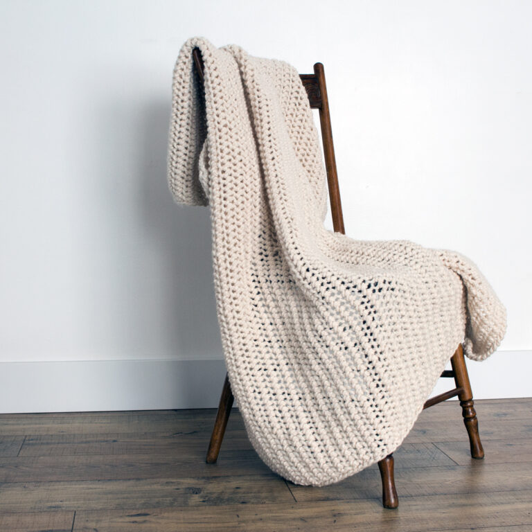 Crochet Knit Blanket draped over a wooden chair.