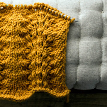 partially knit lace blanket on a cushion