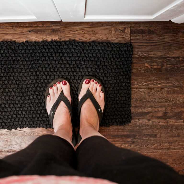 seed stitch knit rug with a model standing on it