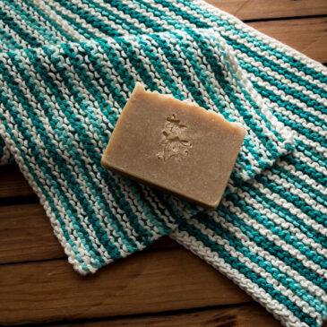 garter stitch dish towel on a wooden table with a bar of soap