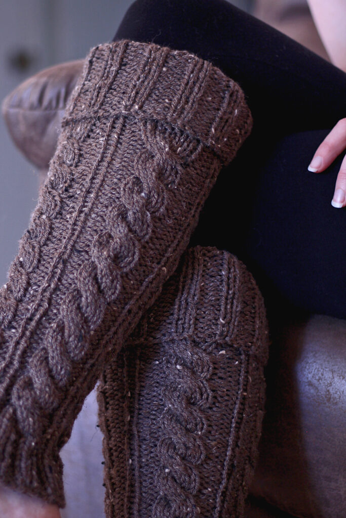 cable knit leg warmers on a faux fur blanket in a cozy setting
