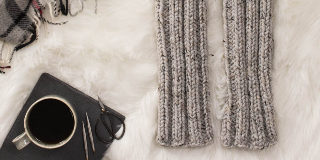 knitted ribbed leg warmers in a cozy setting with a blanket coffee & slippers