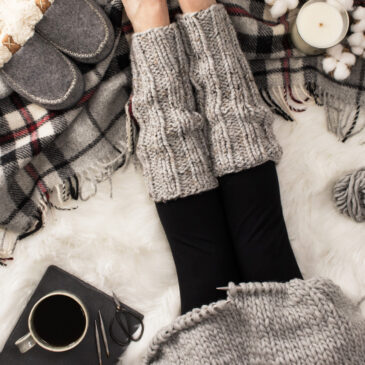 knitted ribbed leg warmers on a model in a cozy setting with a blanket coffee & slippers