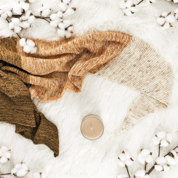 pic of a knitted shawl on a faux fur rug