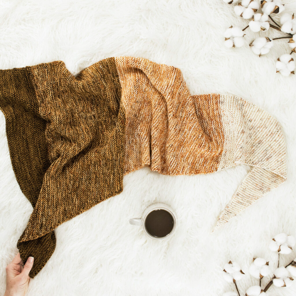 pic of a knitted shawl on a faux fur rug