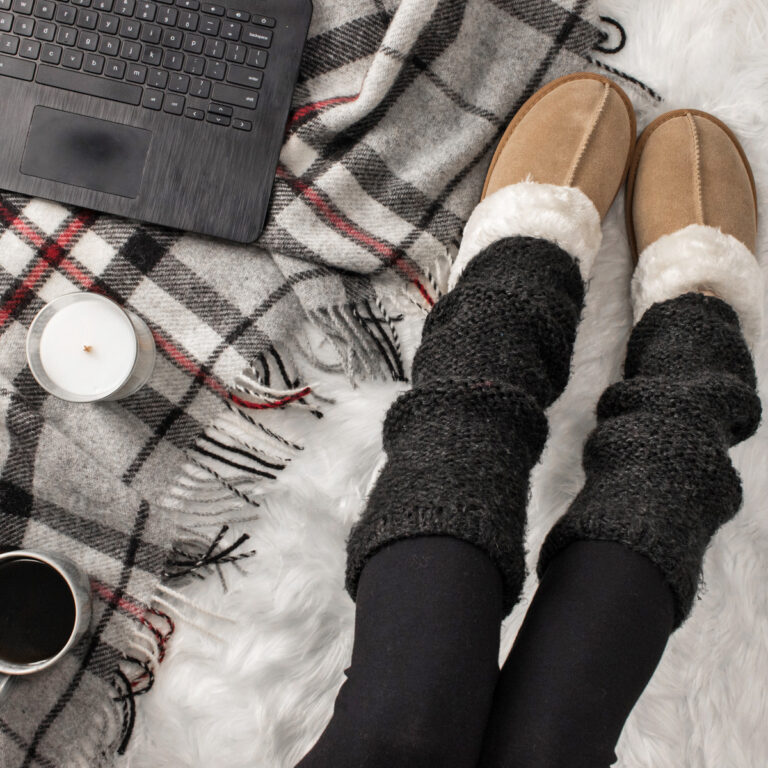 two needle leg warmers on a model a faux fur blanket in a cozy setting