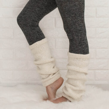 Classic white knitted leg warmers on a model.