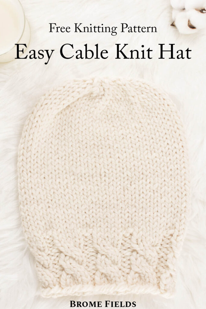 cozy scene of a hand knit chunky cable hat with cotton bolls & a candle