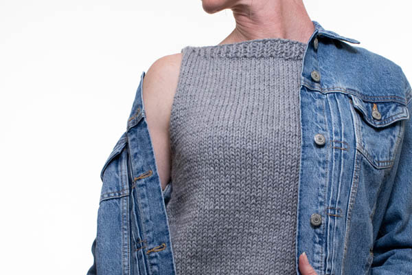 model wearing a mock sweater under a jean jacket.