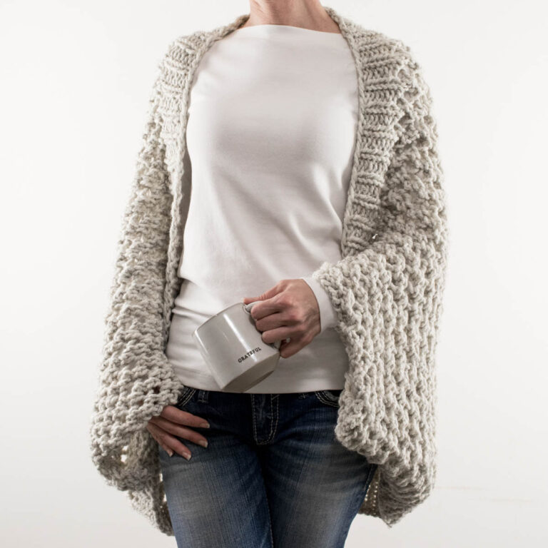 lace knit scoop shrug on a model wearing jeans and a t-shirt holding a mug
