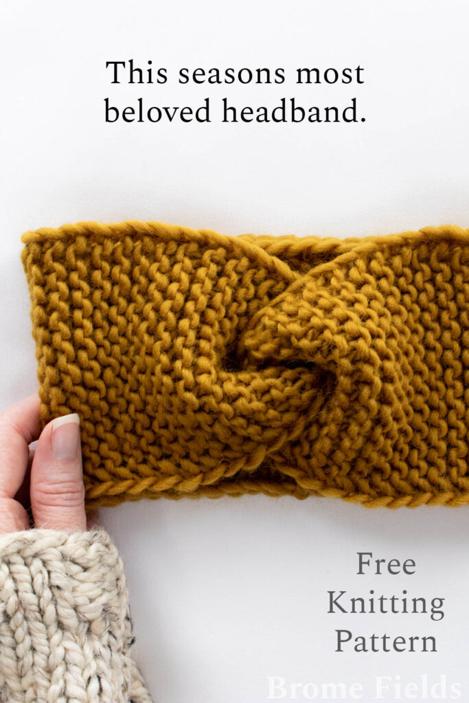 knitted headband laying flat with a hand wearing a sweater holding it.