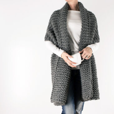 knitted chevron blanket scarf draped over a models shoulders.