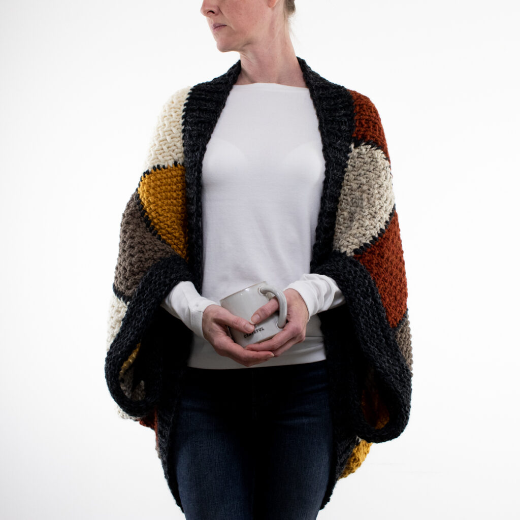 pics of an oversized patchwork knit shrug on a model.