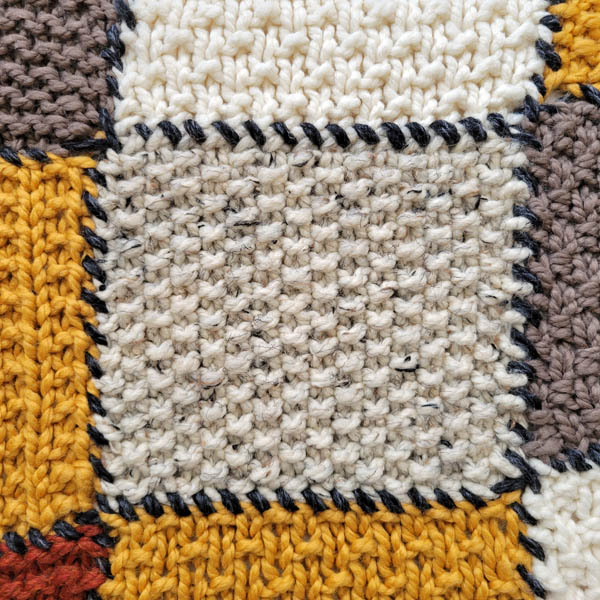 seed stitch swatch on a patchwork blanket
