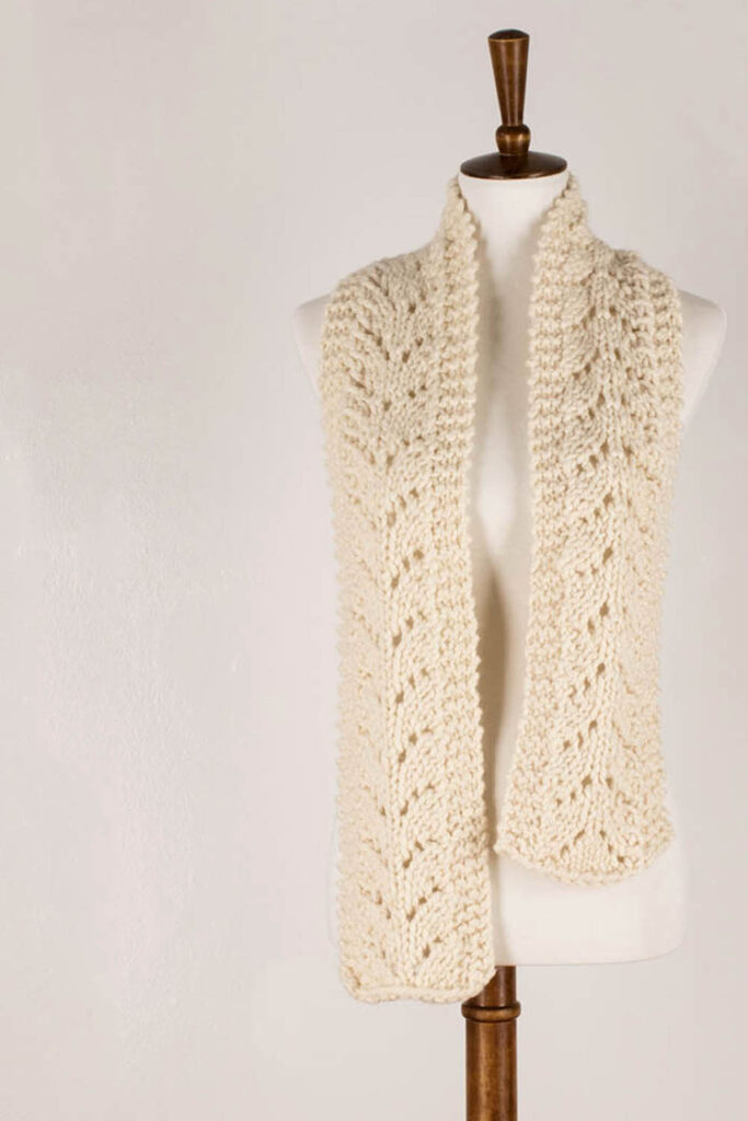 chunky lace knit scarf displayed on a dress form.