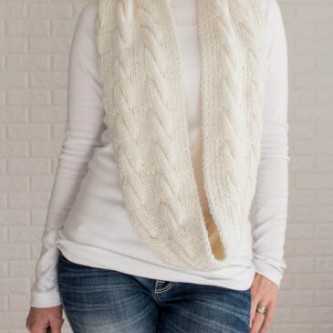knitted cable infinity scarf on a model.