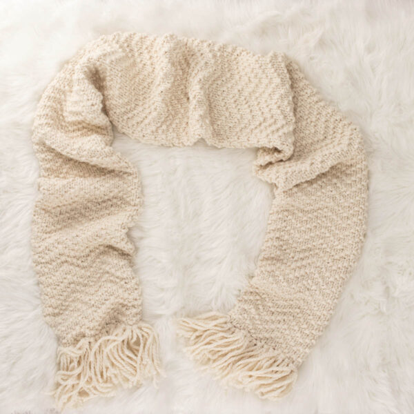 A chevron scarf laying on a faux fur blanket