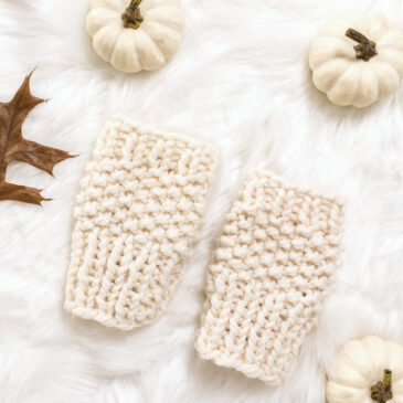 chunky knit fingerless gloves laying on a faux fur blanket