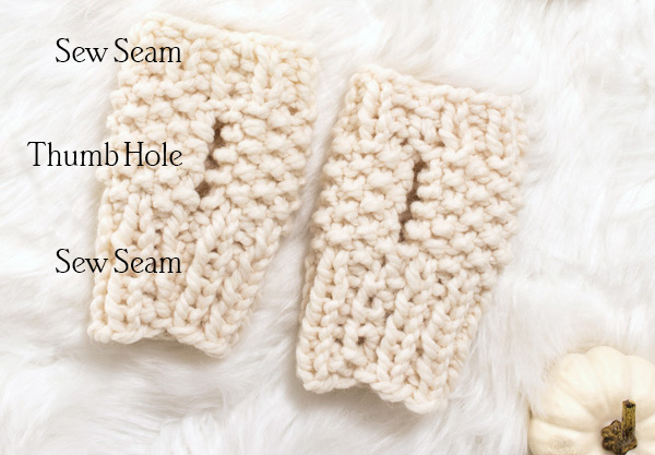 chunky knit fingerless gloves laying on a faux fur blanket showing the thumb hole location