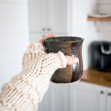 Chunky fingerless gloves with a thumb gusset holding a coffee mug