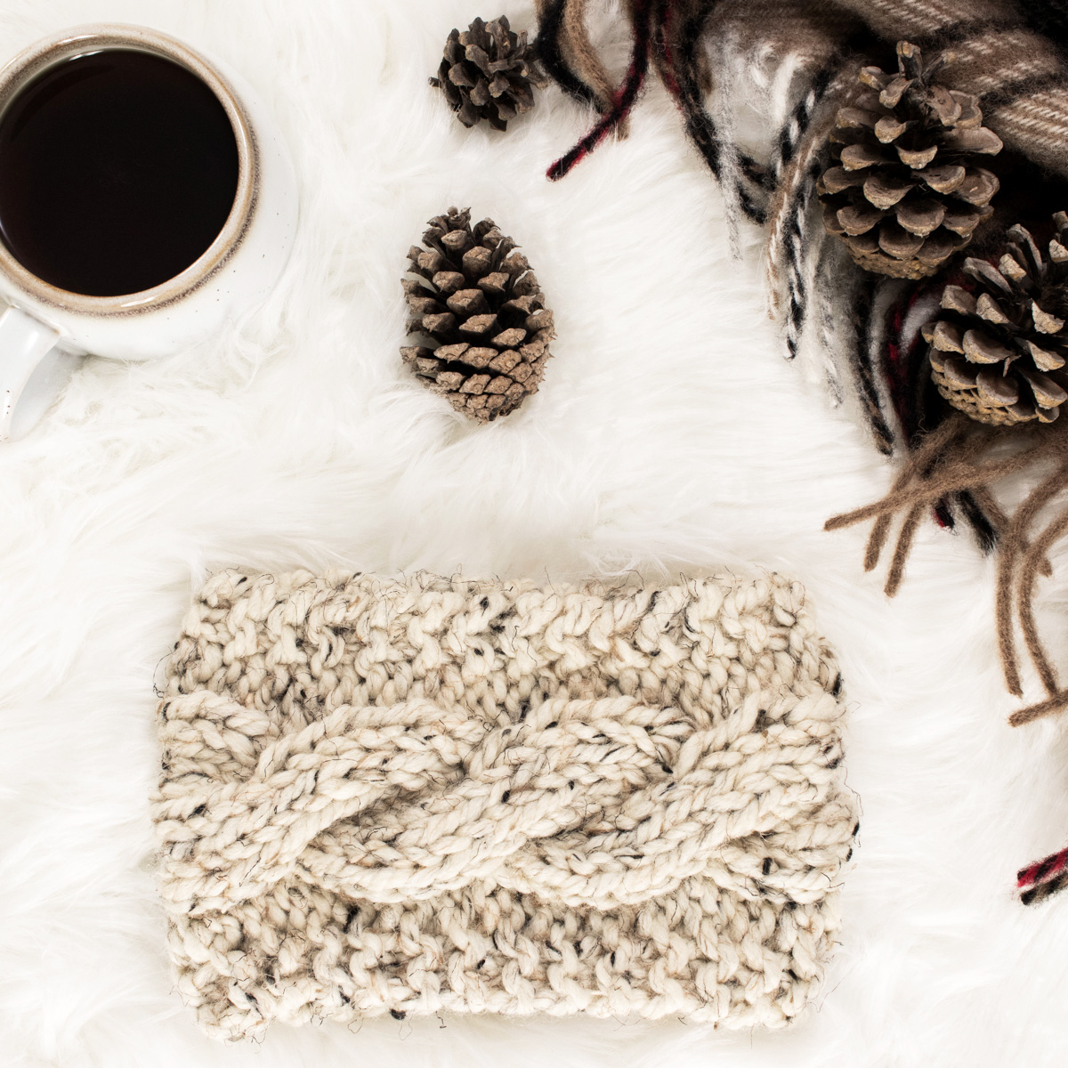 Easy Cable Headband laying on a faux fur blanket