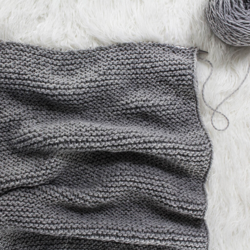 cowl knit with straight needles and on a faux fur blanket