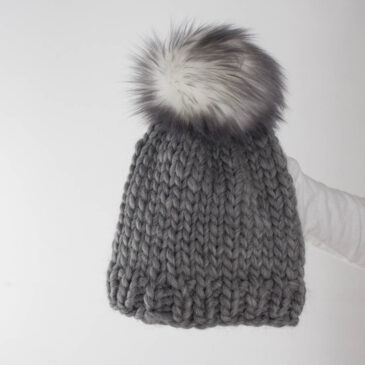 an simple & easy knitted beanie being held by a model