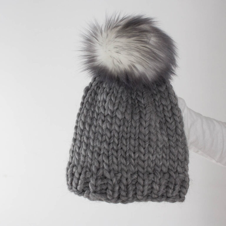 an simple & easy knitted beanie being held by a model