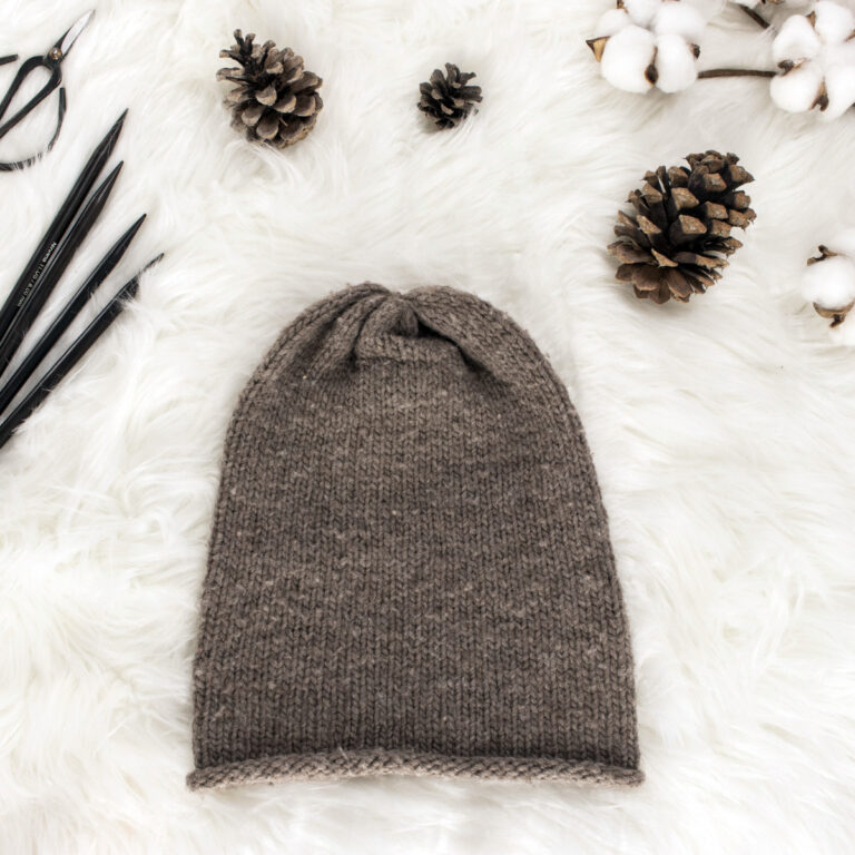 beginner stockinette stitch knit hat displayed on faux fur blanket