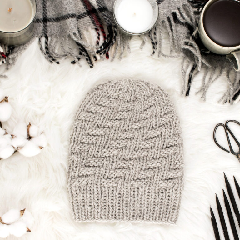 knit & purl hat displayed on faux fur blanket