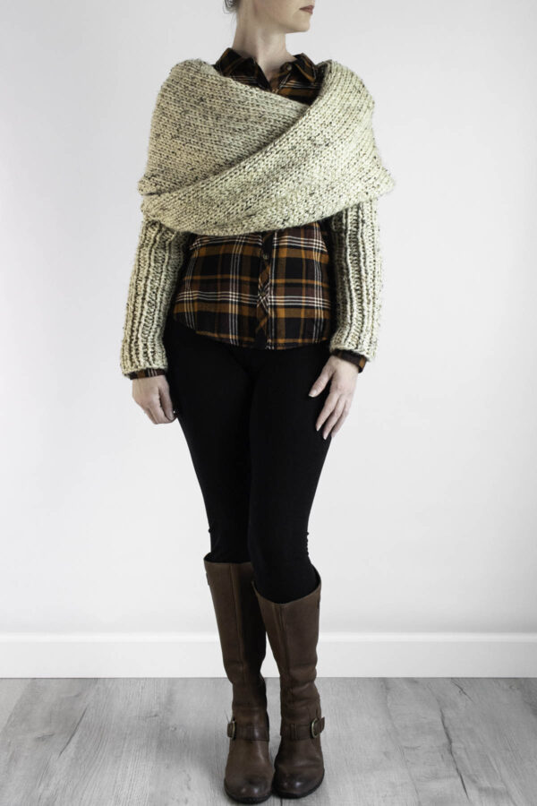 Chunky knit sweater scarf styled over plaid flannel with black leggings and boots