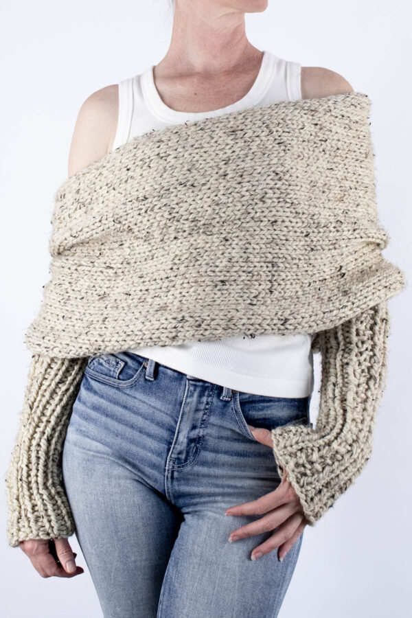 Front view of chunky sweater scarf worn over white tank with ribbed sleeves