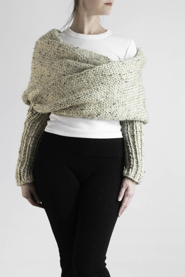 Chunky sweater scarf with long knit sleeves worn over white tee and black leggings