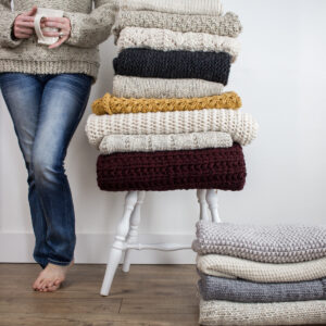 stack of blankets on a chair next to a model