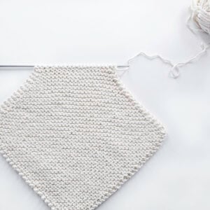 pic of a corner-to-corner dishcloth half knitted, on a knitting needle