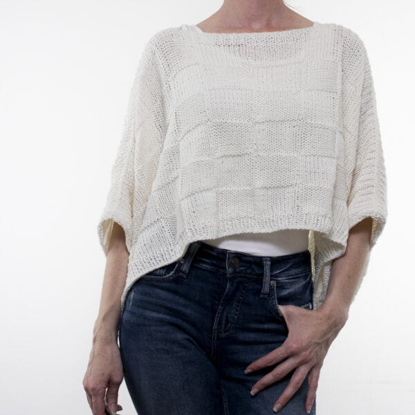 woman wearing oversized seamless quilt poncho, lightweight knit for spring and summer fashion