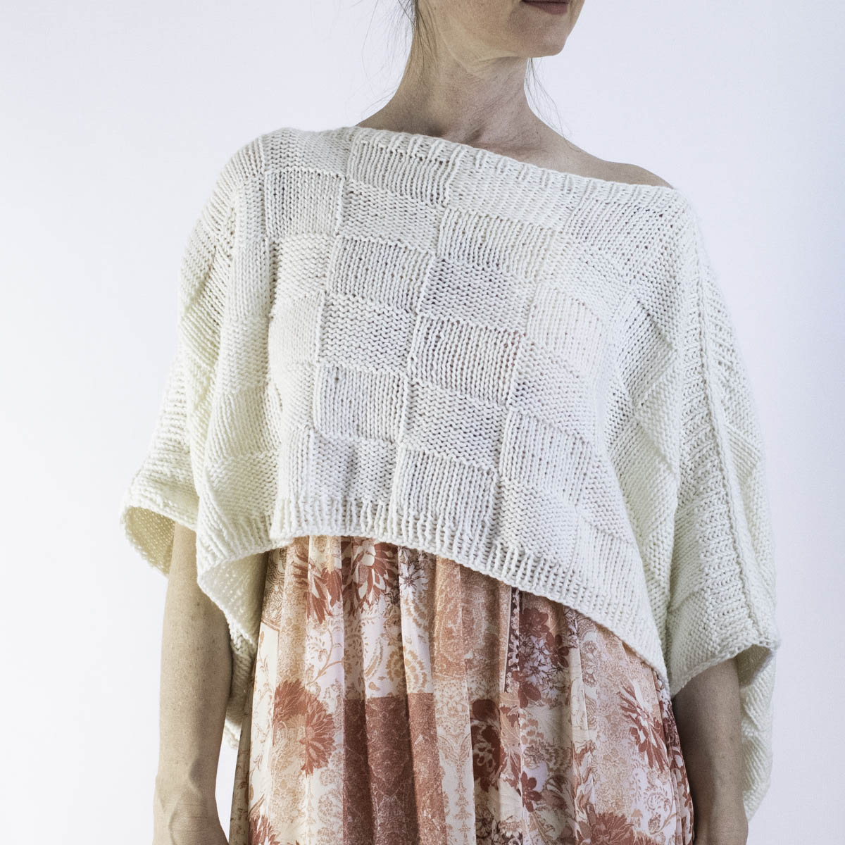 Front view of a lightweight knit poncho worn over a summer dress