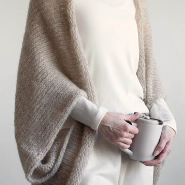 Oversized brushed alpaca shrug draped over shoulders, open front knit cardigan style