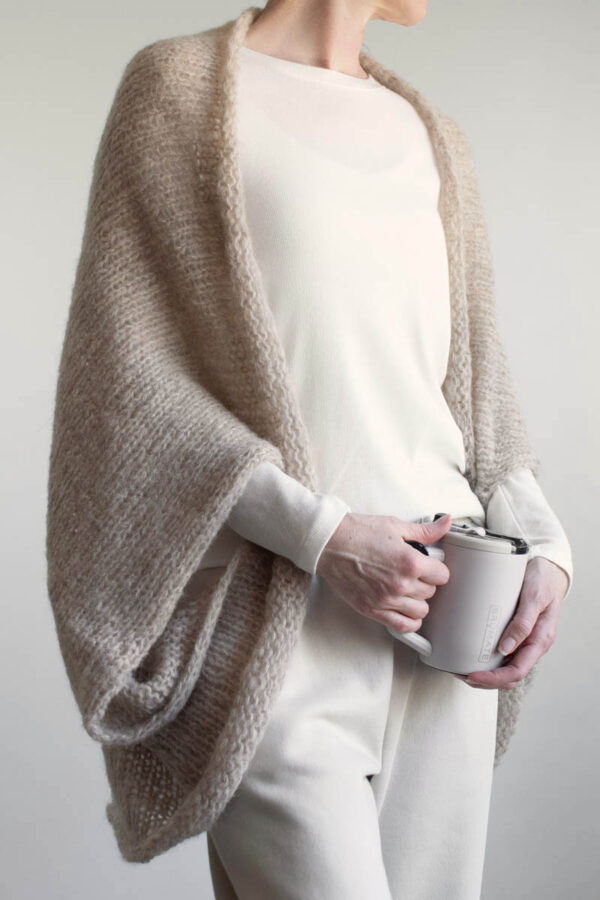 Oversized brushed alpaca shrug draped over shoulders, open front knit cardigan style
