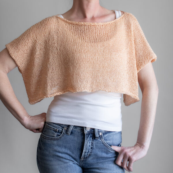 a woman wearing a peach linen knit tee from the front, back, and sides. The boxy cropped top has short sleeves and a wide neckline.