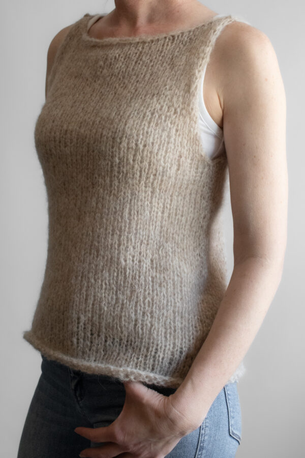 A model wearing a handknitted brushed alpaca tank top in oatmeal, shown from the front angle.