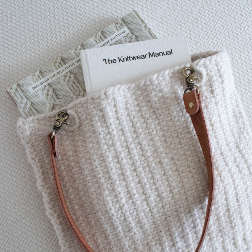 Pic of a linen stitch tote bag with books peeking out of the top