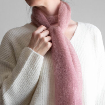 Simple, one skein soft pink lightweight knit scarf worn by a model