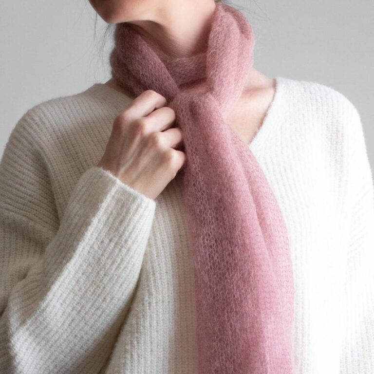 Simple, one skein soft pink lightweight knit scarf worn by a model