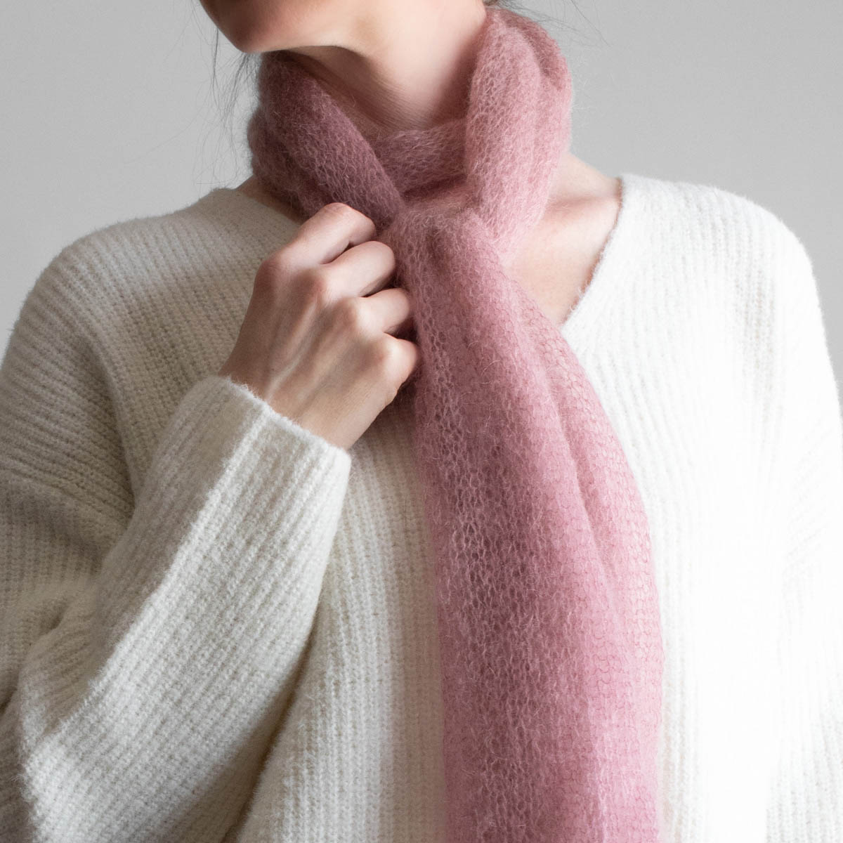Simple, one skein soft pink lightweight knit scarf worn by a model
