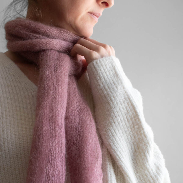 Simple, one skein soft pink lightweight knit scarf worn by a model