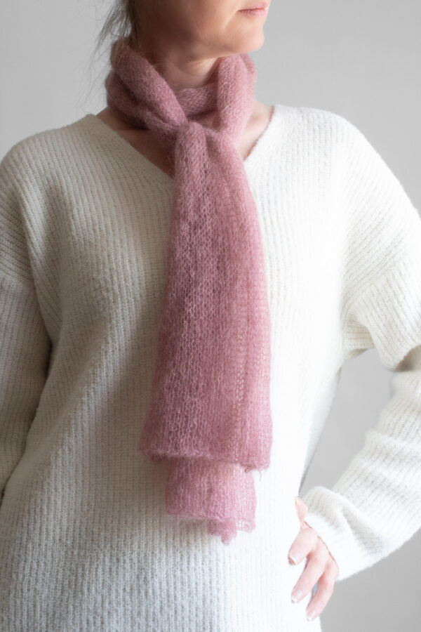 Simple, one skein soft pink lightweight knit scarf worn by a model