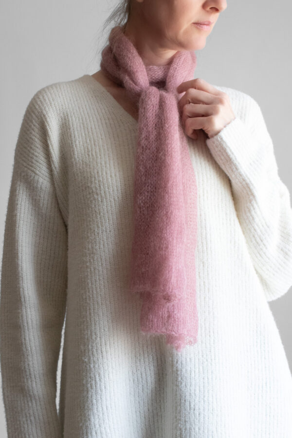 Simple, one skein soft pink lightweight knit scarf worn by a model