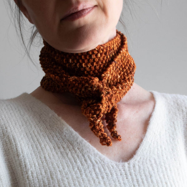 Textured seed stitch skinny scarf in autumn colors, tied at the neck